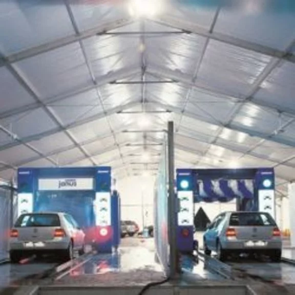 A car wash with two cars in an industrial tent