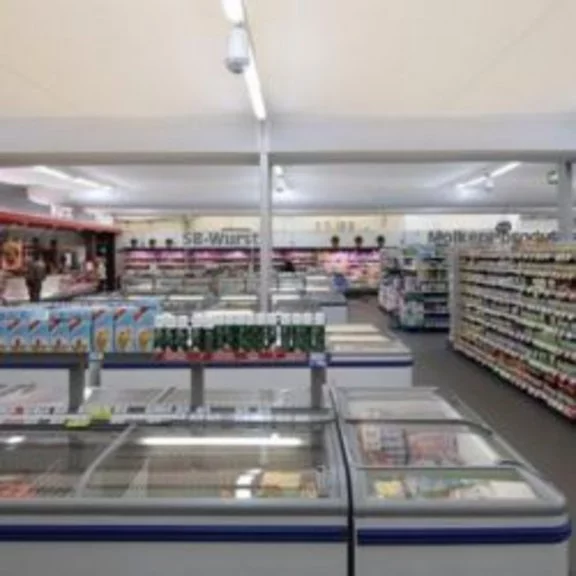 Sales room of a supermarket with freezers in an industrial tent