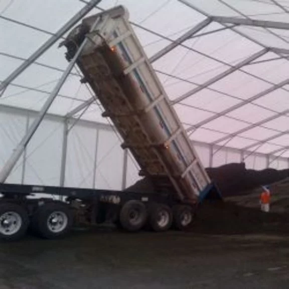 A lorry unloads bulk goods in a large RÖDER tent warehouse